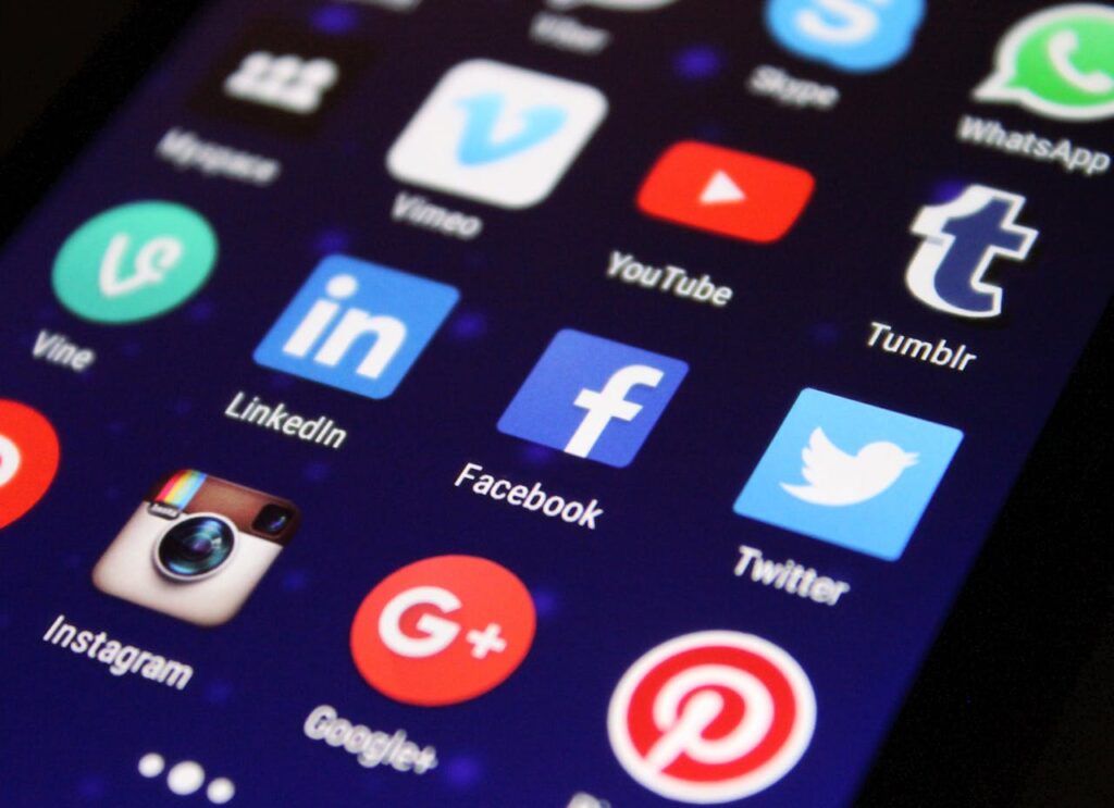 pexels-photo-267350 Close-up of a smartphone screen showing various social media app icons such as Facebook and Twitter.